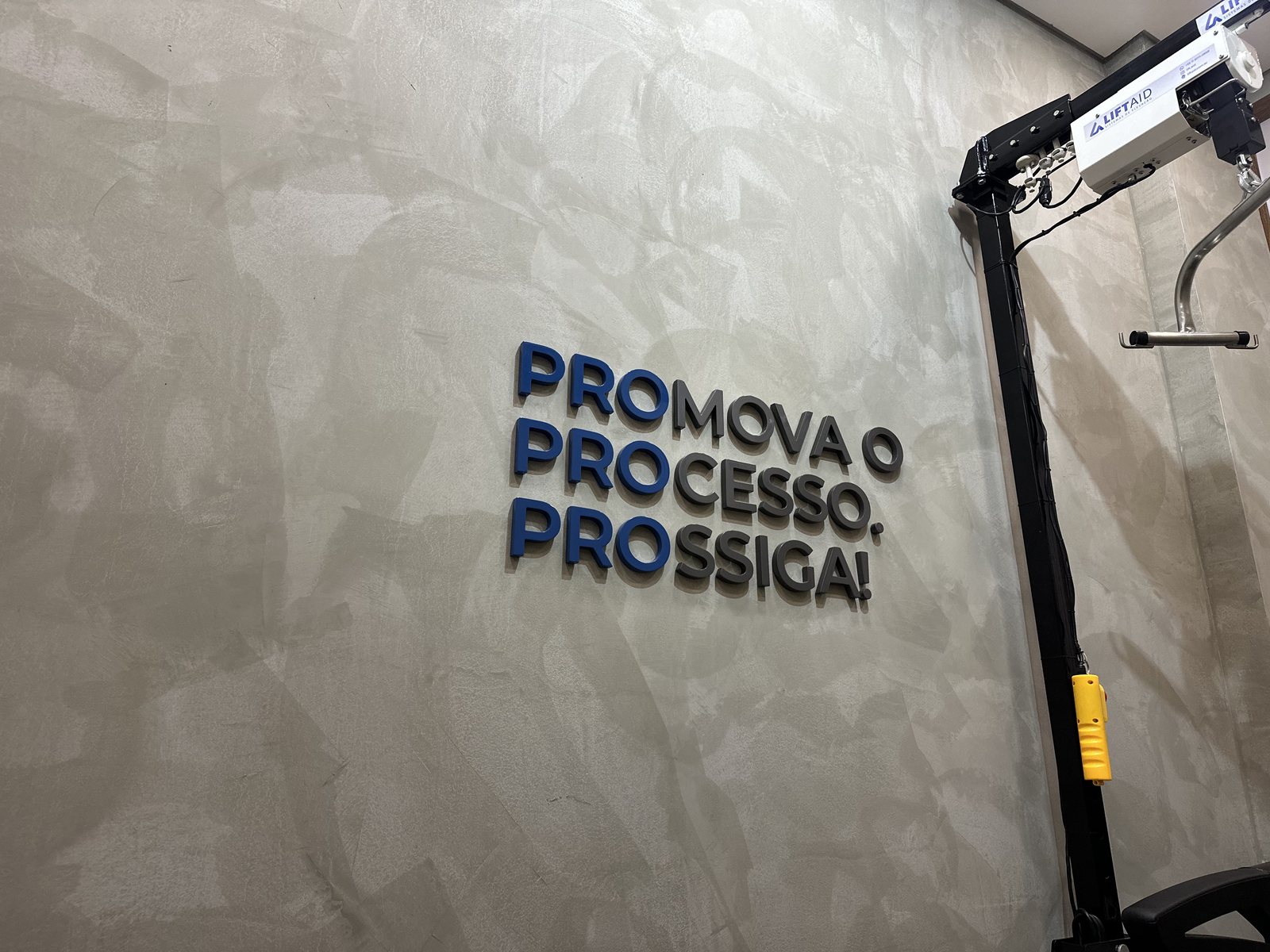 Parede com a identidade PRO Fisioterapia e equipamento clínico